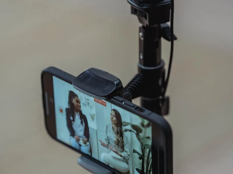 Smartphone mounted on a tripod recording video content